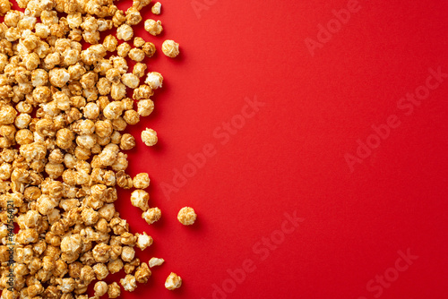 Overhead shot of a pile of delectable popcorn against red background, with space for your message or promotion