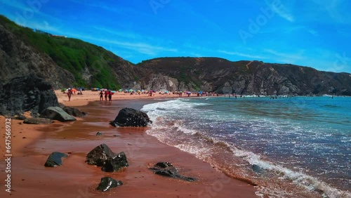 People enjoying the sand and sun at Praia da Amália Beach, Portugal photo