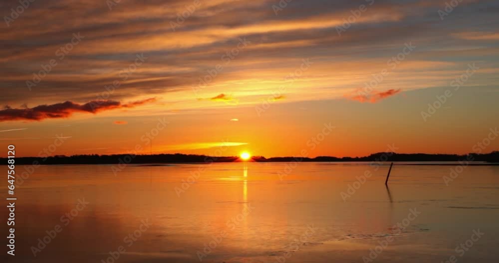 Sunset with sky colors reflecting on frozen sea surface in autumn, Katajanokka, Helsinki, Finland.