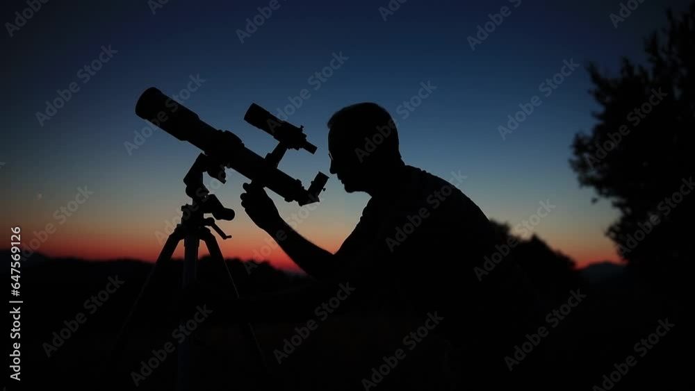 Astronomer looking at the night sky with a telescope.
Astronomer looking at the night sky with a telescope.