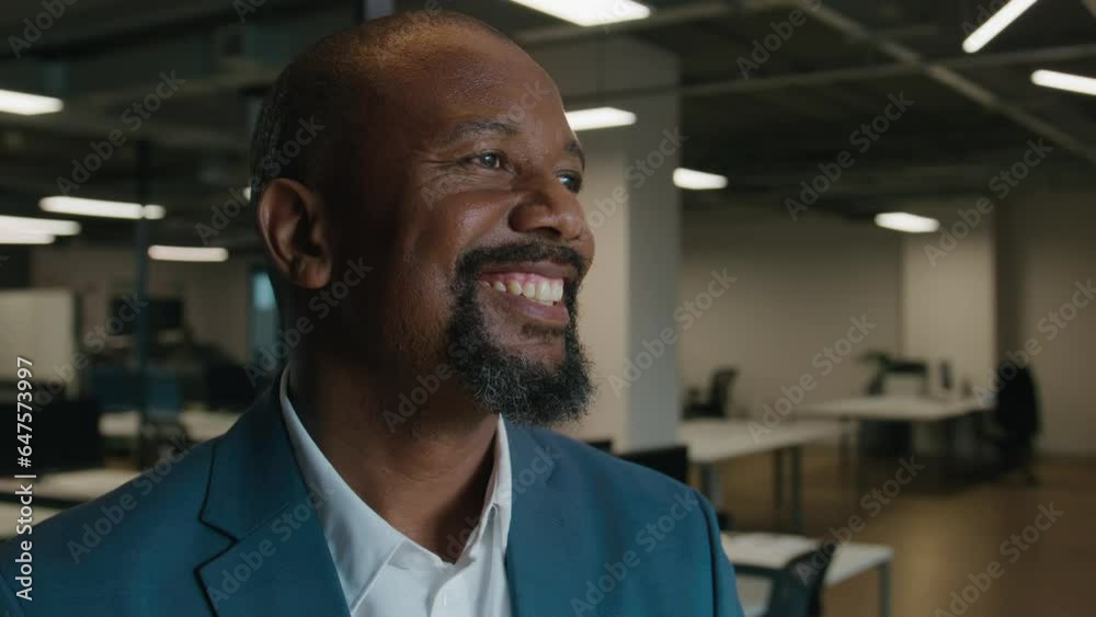 Portrait of happy mature black man in businesswear looking away by desk in office Portrait of happy mature black man in businesswear looking away by desk in office