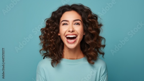 Charming cheerful young woman demonstrating advertising copy  blank space  bright blue background.