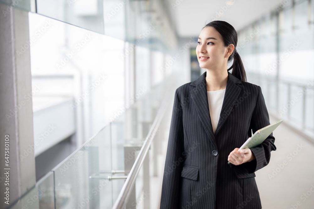 Asian business woman holding a tablet looking away, Fashion business photo of beautiful girl in casual suite with tablet . Asian business woman holding a tablet looking away, Fashion business photo of beautiful girl in casual suite with tablet .