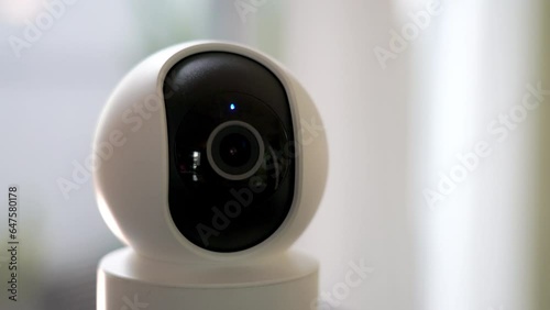 in the living room. Home security cameras are filming around controlled by a smartphone. The robot's home security camera scans its surroundings. A smart home surveillance system that works remotely.