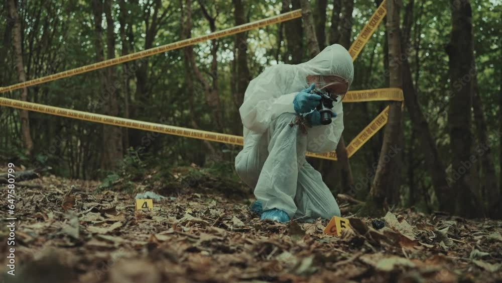 Woman forensic police investigator taking pictures of evidences on a crime scene