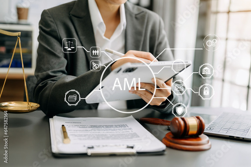 AML Anti Money Laundering Financial Bank Business Concept. judge in a courtroom using laptop and tablet with AML anti money laundering icon on virtual  screen. .