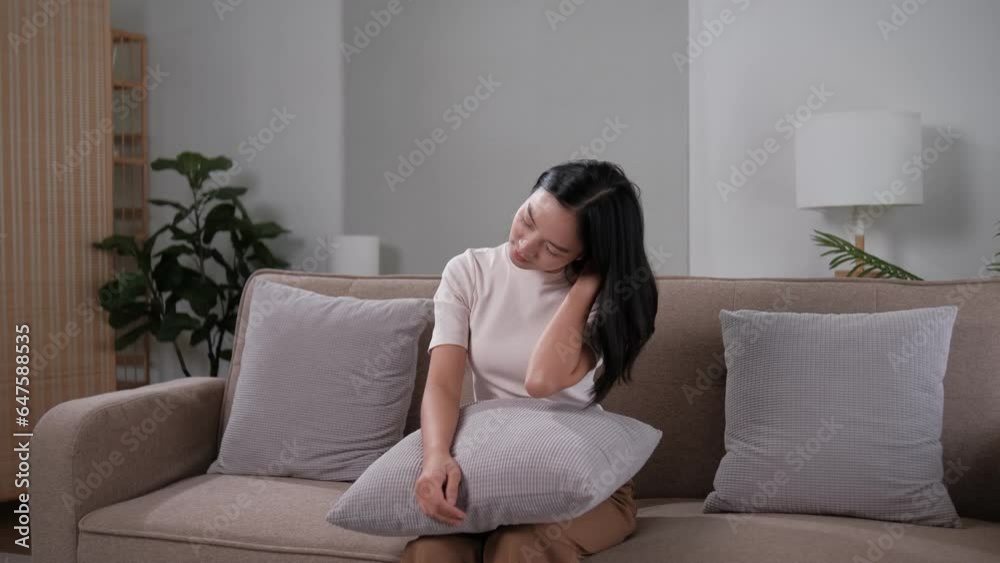 Unhappy young woman touching forehead, yearning, thinking about relationship problems, feeling depressed and lonely, sitting on couch alone, frustrated female suffering from headache or migraine Unhappy young woman touching forehead, yearning, thinking about relationship problems, feeling depressed and lonely, sitting on couch alone, frustrated female suffering from headache or migraine