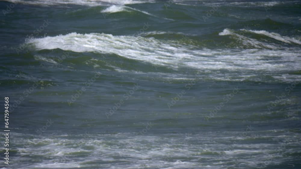 Sunlit shores witness the majestic onslaught of stormy waves, with bursts of water and frothy foam. Sunlit shores witness the majestic onslaught of stormy waves, with bursts of water and frothy foam.