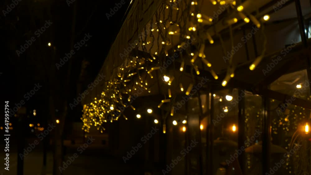 Yellow night decorative lights on caffee. Pretty yellow decorative lights under caffee entrance during night time.
