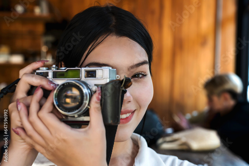 Portrair young woman using vintage camera taking pictures © Jack Tamrong