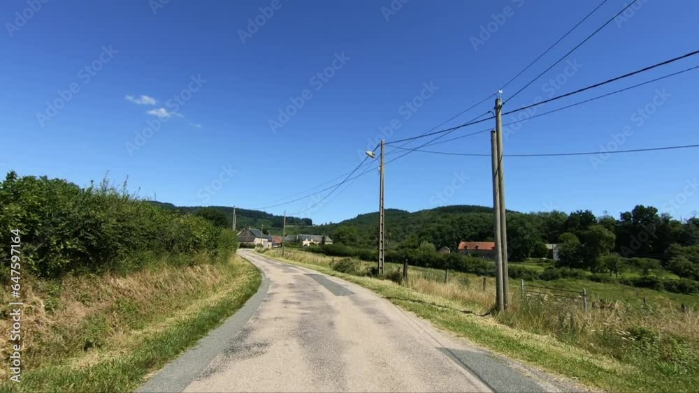A drive stretches through the green countryside in Europe, France, Burgundy, Nievre, towards Chateau Chinon, in summer, on a sunny day. A drive stretches through the green countryside in Europe, France, Burgundy, Nievre, towards Chateau Chinon, in summer, on a sunny day.