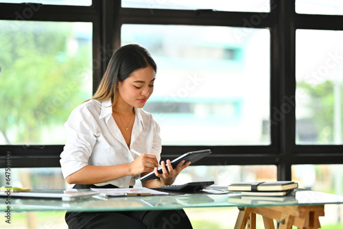 Millennial female entrepreneur doing financial affairs or checking email on digital tablet Free Download Millennial female entrepreneur doing financial affairs or checking email on digital tablet - GFXLoad