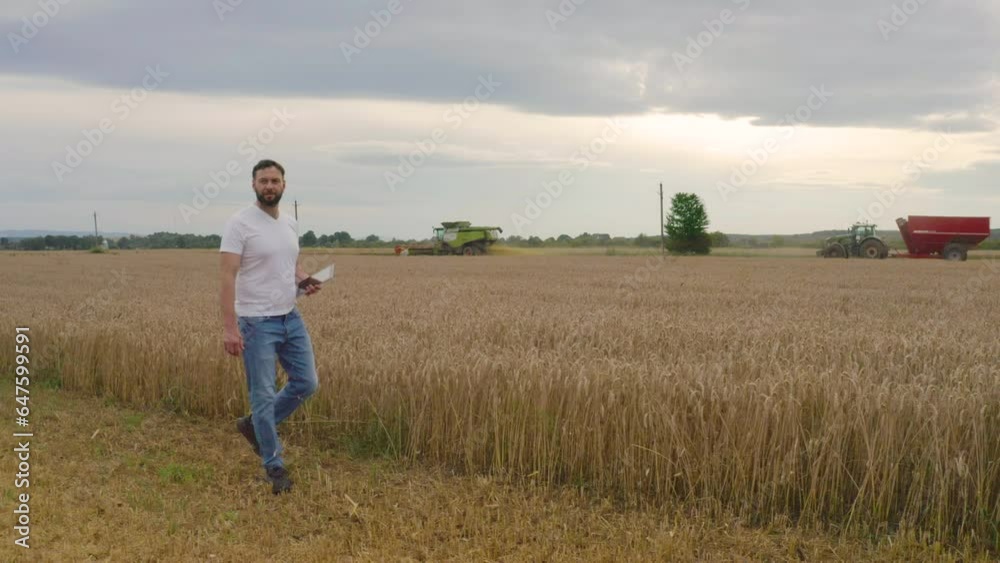 Male farmer with tablet computer in wheat field walking and checking wheat quality and job well done. Male farmer with tablet computer in wheat field walking and checking wheat quality and job well done.