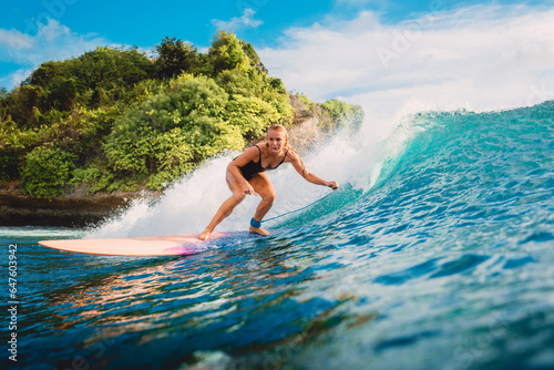Canvas Print Attractive surf girl riding on surfboard in ocean
