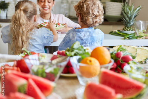 Kids preparing food with mother in kitchen