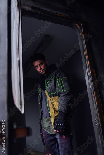 gloomy man in black jacket looking at camera in abandoned subway carriage, post-apocalyptic concept © LIGHTFIELD STUDIOS