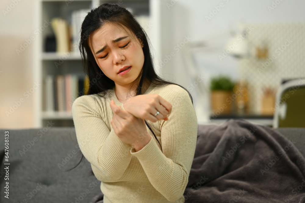 Unhappy woman suffering from pain in hand or wrist, having osteoarthritis rheumatoid arthritis, health care problem Unhappy woman suffering from pain in hand or wrist, having osteoarthritis rheumatoid arthritis, health care problem