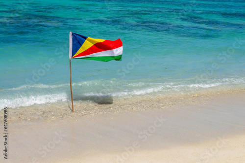 Seychelles flag, white sand beach and turquoise water background with copy space