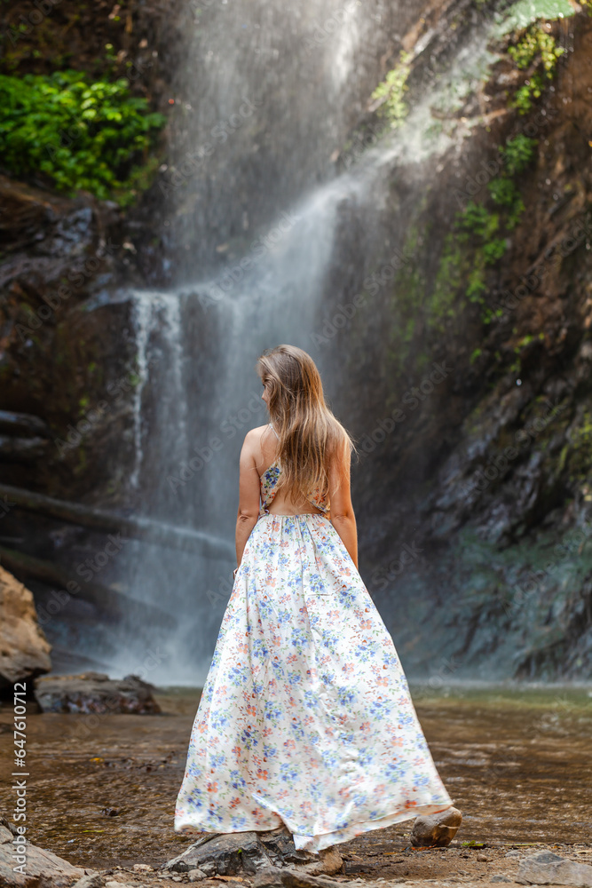 Mountain waterfall, woman back view. Natures grandeur, cascading waters. Adventure in lush greenery, Thailand hidden treasure.