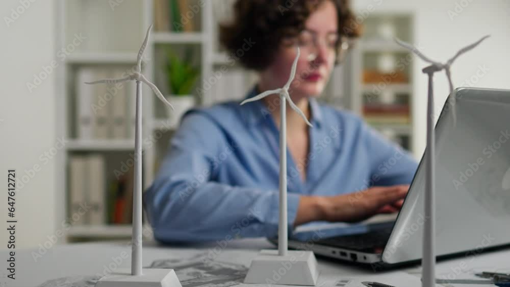 Turbine. Design Engineer Brainstorming with Colleagues, Young Woman Working on Laptop Creating New Tactics to Bypass Competitors in Wind Power Business Turbine. Design Engineer Brainstorming with Colleagues, Young Woman Working on Laptop Creating New Tactics to Bypass Competitors in Wind Power Business