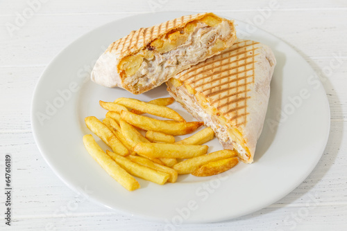 Tacos français sur une assiette avec des frites et sauces.  photo