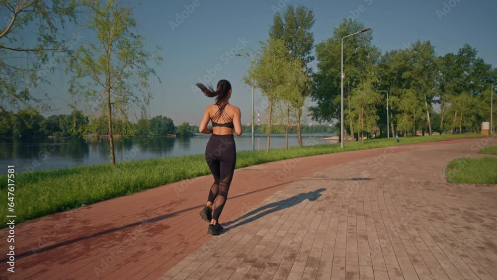 rear view woman running along the river in summer park aerobic exercise in the morning slow motion rear view woman running along the river in summer park aerobic exercise in the morning slow motion