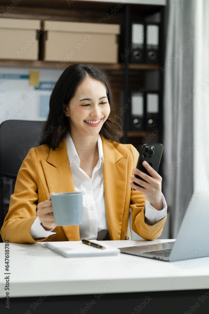 Asian business woman using mobile phone in office. Asian business woman using mobile phone in office.