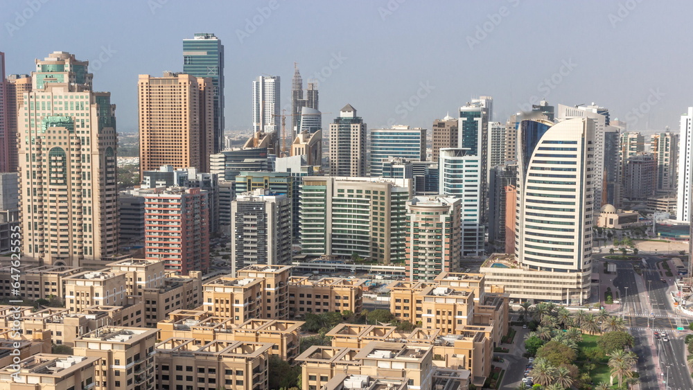 Skyscrapers in Barsha Heights district and low rise buildings in Greens district aerial all day timelapse. Dubai skyline