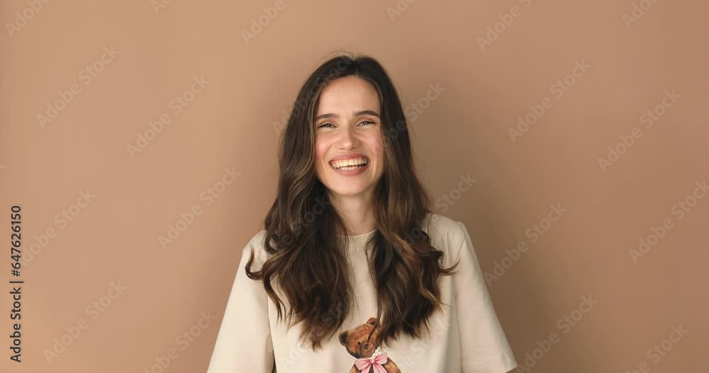 Young woman pointing with finger gun gesture, looking confident, shooting killing with hand pistol right on target, shooting to camera, having fun. Girl isolated alone on beige studio background. Young woman pointing with finger gun gesture, looking confident, shooting killing with hand pistol right on target, shooting to camera, having fun. Girl isolated alone on beige studio background.