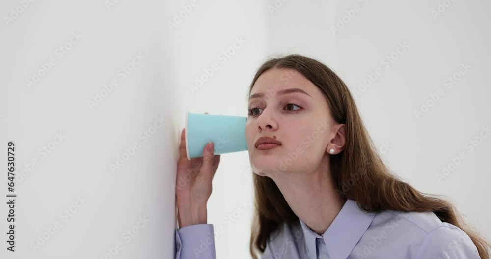 Lady office employee trying to eavesdrop to CEO-workers conversation using paper cup. Concept of inappropriate behaviour and allegations in company office Lady office employee trying to eavesdrop to CEO-workers conversation using paper cup. Concept of inappropriate behaviour and allegations in company office