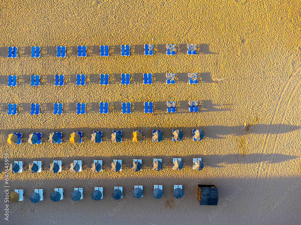 Aerial view landscape, view of an empty, clean, beautiful beach with sun loungers and umbrellas. Photo from a drone. Portugal, Albufeira, Algarve region. Praia to Tunel.