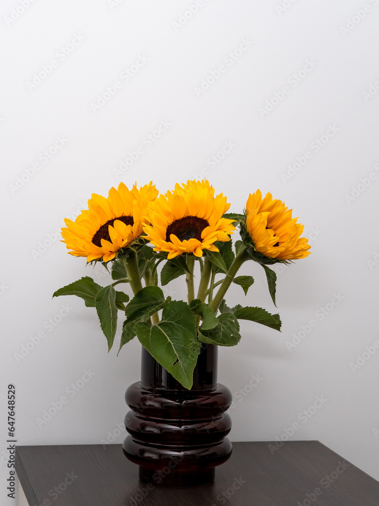 Bouquet of sunflowers in a vase close-up on a light background Bouquet of sunflowers in a vase close-up on a light background