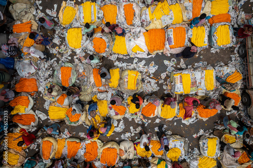 Aerial view of Mallick Ghat flower market under Howrah Bridge on the banks of the Hooghly river in Kolkata, West Bengal, India.