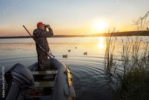 hunter with shotgun hunting of ducks. duck hunting at sunrise.