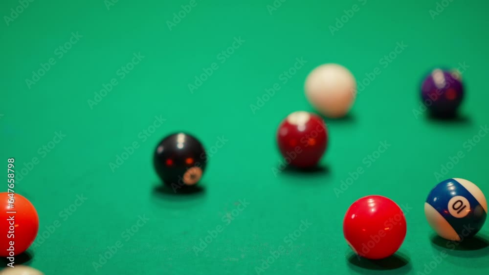 A young man plays Russian billiards, an American woman in a billiards club and bar. Dark colors in the billiard club. A man pockets snooker balls. A young man plays Russian billiards, an American woman in a billiards club and bar. Dark colors in the billiard club. A man pockets snooker balls.