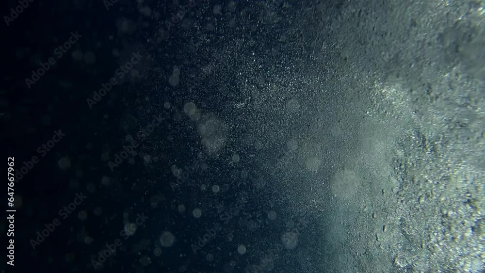 Air bubbles under churning surface of water at sunset, underwater shot Air bubbles under churning surface of water at sunset, underwater shot