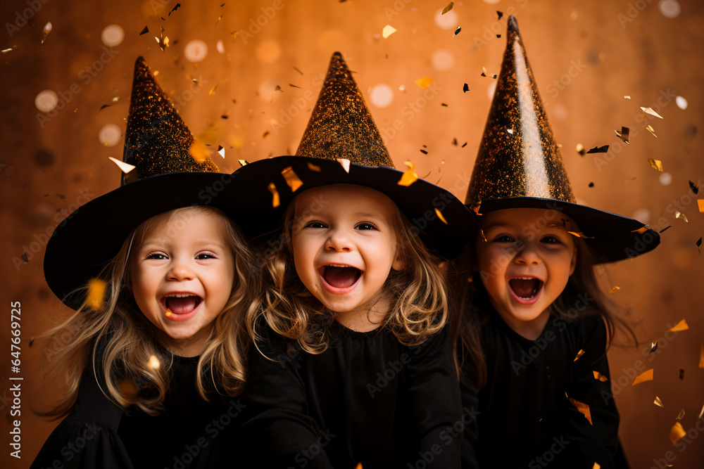 little girls in Halloween witch costume on orange background with flying confetti, candid little girls in Halloween witch costume on orange background with flying confetti, candid