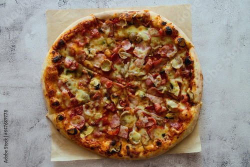 Delicious pizza with sausage, tomatoes and cheese