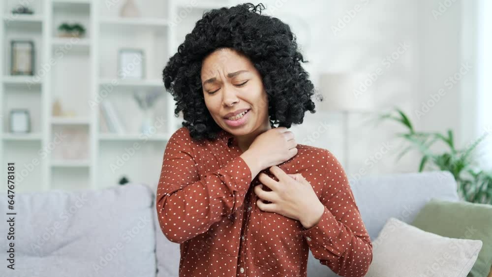 Allergy attack Itch or pruritus Young african american female scratching suffering from allergic reaction or mosquito bite sitting on sofa at home. Black woman has as a result of stress scratches body Allergy attack Itch or pruritus Young african american female scratching suffering from allergic reaction or mosquito bite sitting on sofa at home. Black woman has as a result of stress scratches body