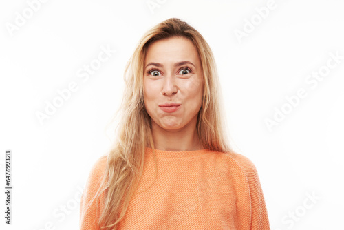 Portrait of young blond woman puffing cheeks with funny face isolated on white studio background. Humor concept, mouth inflated with air crazy expression. photo