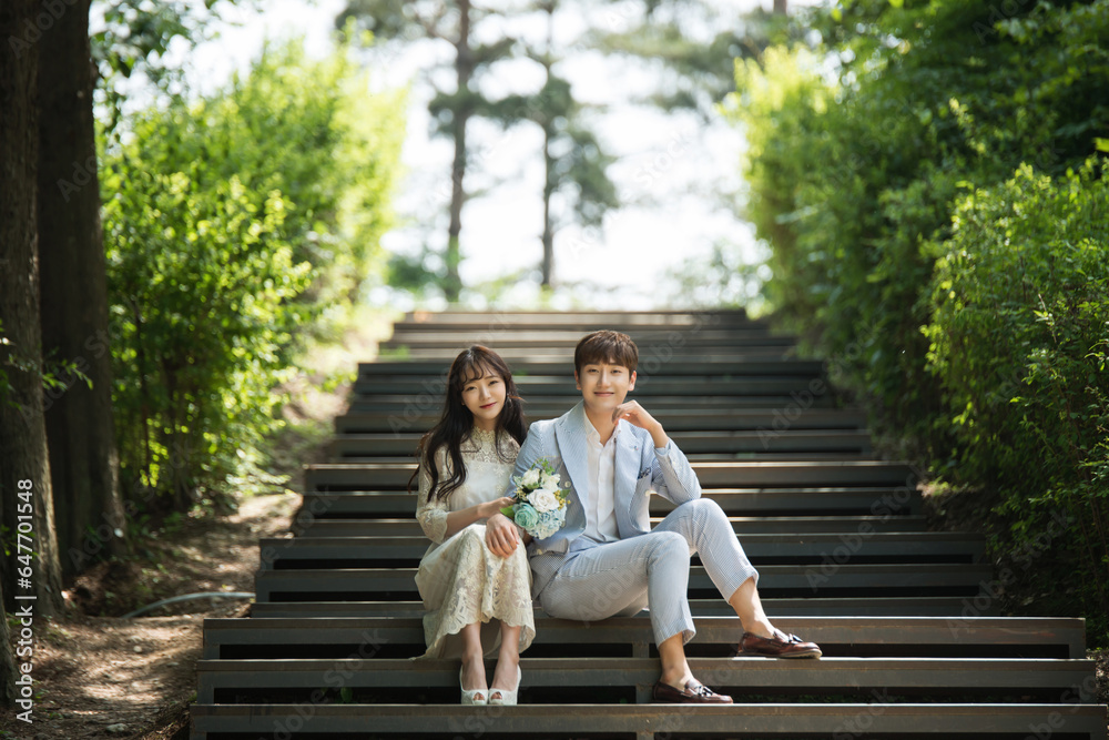 A loving couple are sitting on the steps of the park and taking wedding pictures for their wedding. A loving couple are sitting on the steps of the park and taking wedding pictures for their wedding.