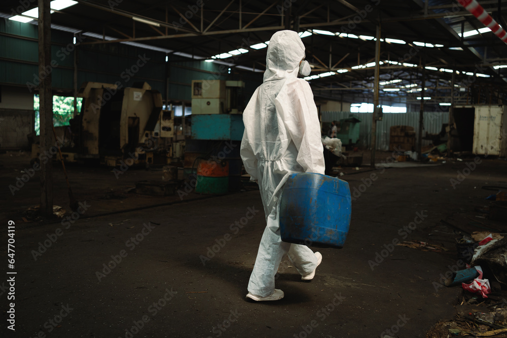 Management of hazardous chemicals in factories. Industrial workers wear hazmat suits in manufacturing plants. Management of hazardous chemicals in factories. Industrial workers wear hazmat suits in manufacturing plants.