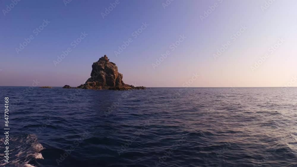 still view look out to Peaked rock islet migration bird sanctuary protective zone with sunlight on surface at the calm quiet ocean sea horizon slow motion during sunset with clear blue sky day time still view look out to Peaked rock islet migration bird sanctuary protective zone with sunlight on surface at the calm quiet ocean sea horizon slow motion during sunset with clear blue sky day time
