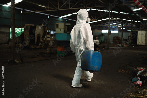 Management of hazardous chemicals in factories. Industrial workers wear hazmat suits in manufacturing plants.