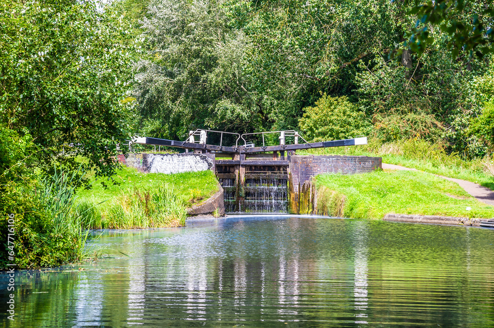 A view towards a closed lock gate filling up on the Erewash canal in summertime A view towards a closed lock gate filling up on the Erewash canal in summertime