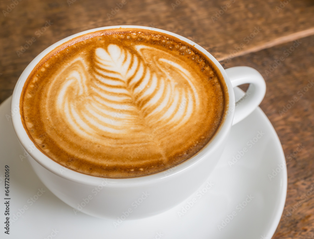 latte art rosetta in a white cup on a wooden table latte art rosetta in a white cup on a wooden table