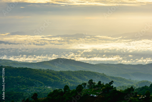 Fototapeta Naklejka Na Ścianę i Meble -  Soft golden light with sky clouds and sunrise in the morning, fog cover the jungle hill and village in northern of Thailand.