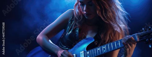 Young female musician playing guitar at a rock concert