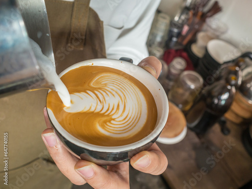 barista pouring milk latte art