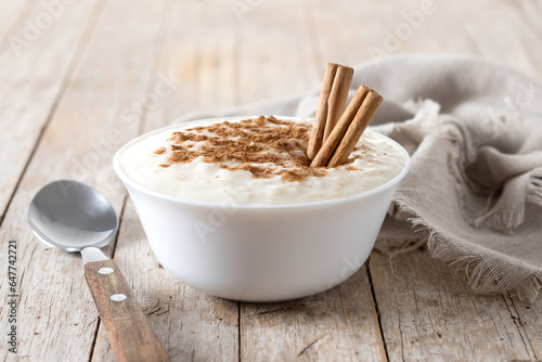 Arroz con leche. Rice pudding with cinnamon in bowl on wooden table